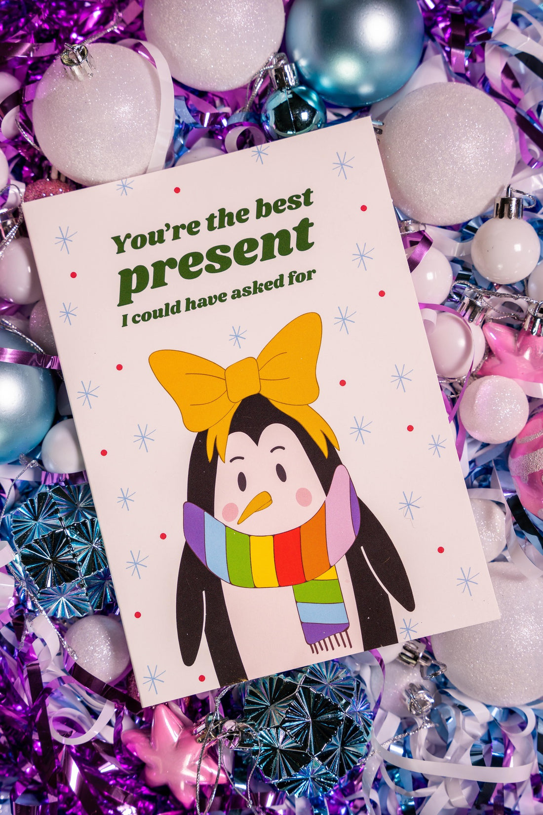 'Youre the best present I could have asked for' card with a penguin illustration and text surrounded by festive ornaments