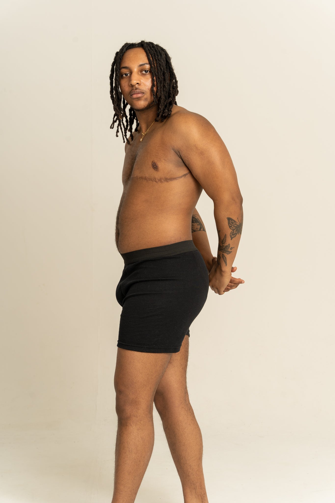 Man wearing black boxers against a beige background