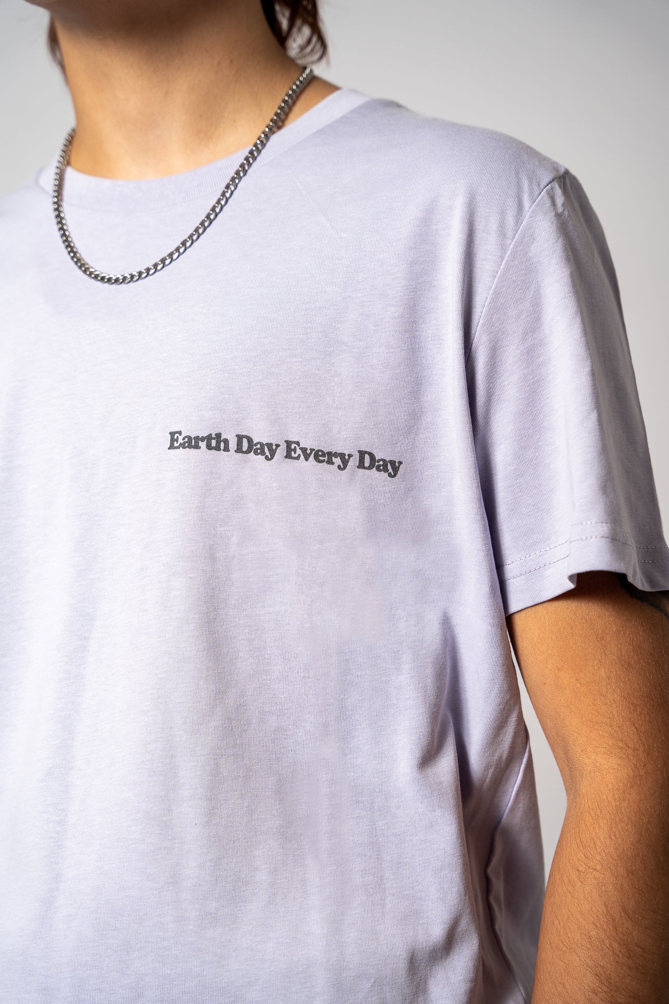 A close-up on a lilac t-shirt with 'Earth Day Every Day' 